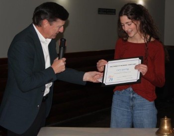 Thad Hall presents a certificate and check to Caris Goering, Optimist's Manhattan High School Student of the Month